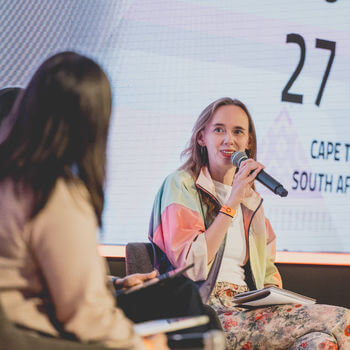 Lady speaking into microphone while on stage