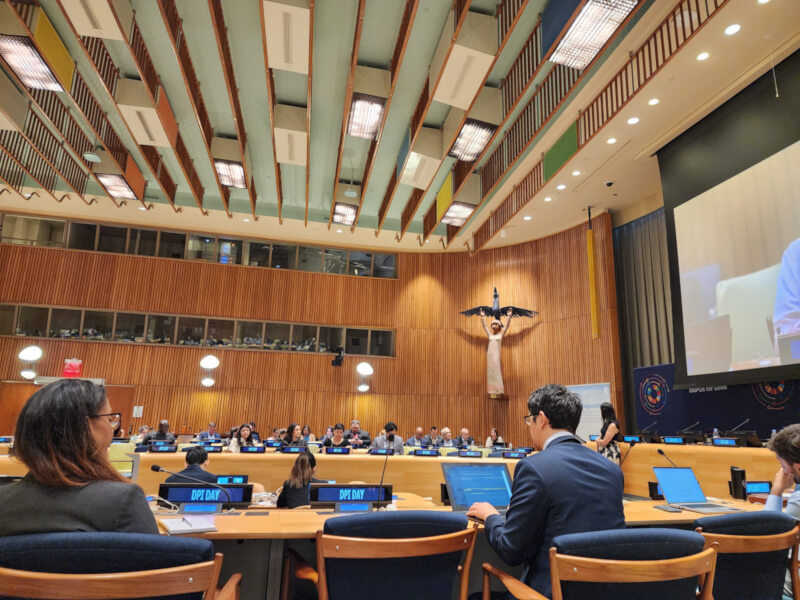 Participants at UN Open Source Week seated at tables with laptops and microphones inside a conference room at United Nations Headquarters in New York City.